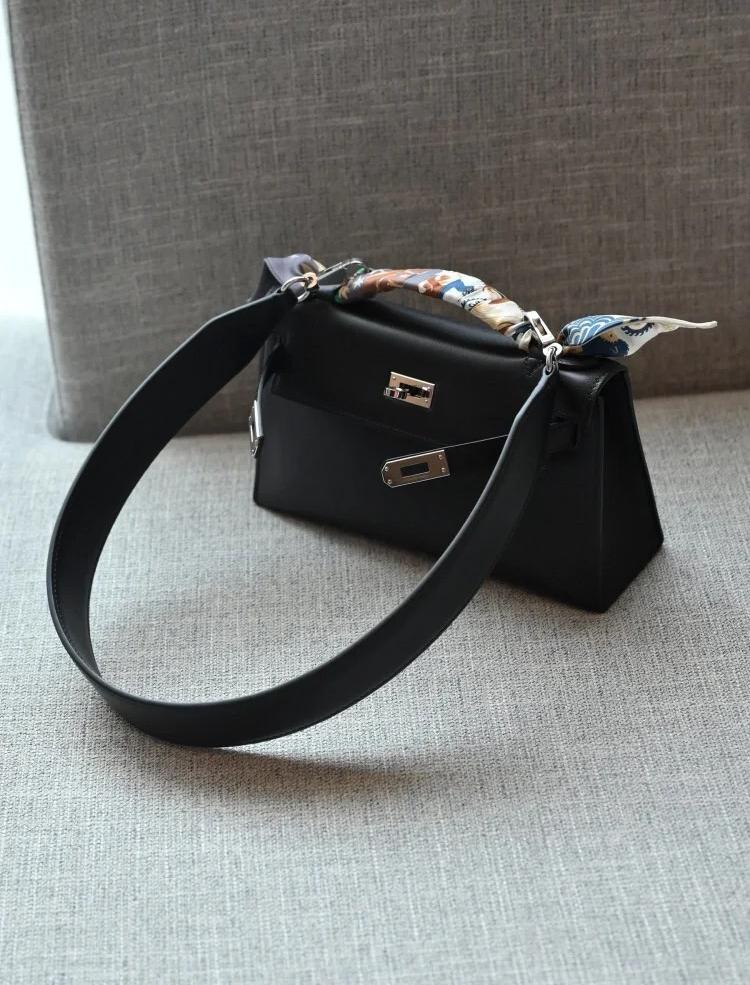 A close-up of the Hermès Kelly Pochette in black leather