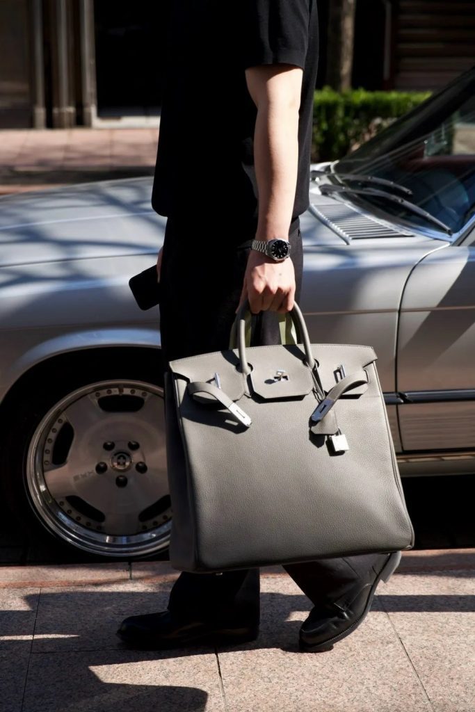 Man walking with a Hermes HAC 40 Birkin bag in Etain grey leather
