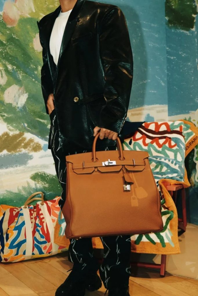 Model posing with Hermes HAC bag in gold leather