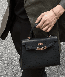 A black Hermes Kelly ostrich bag with gold hardware