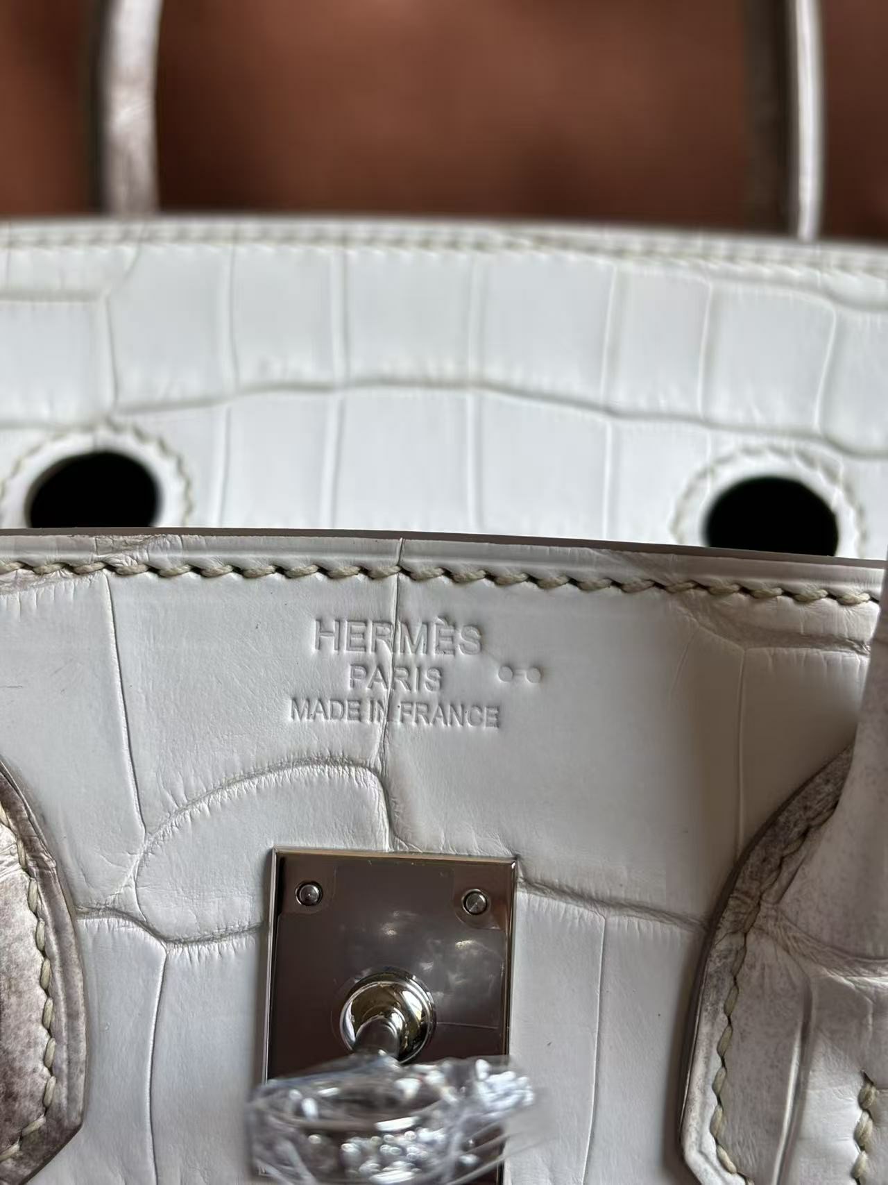 Macro view of the 'Hermès Paris Made in France' foil stamp on a Himalayan Birkin
