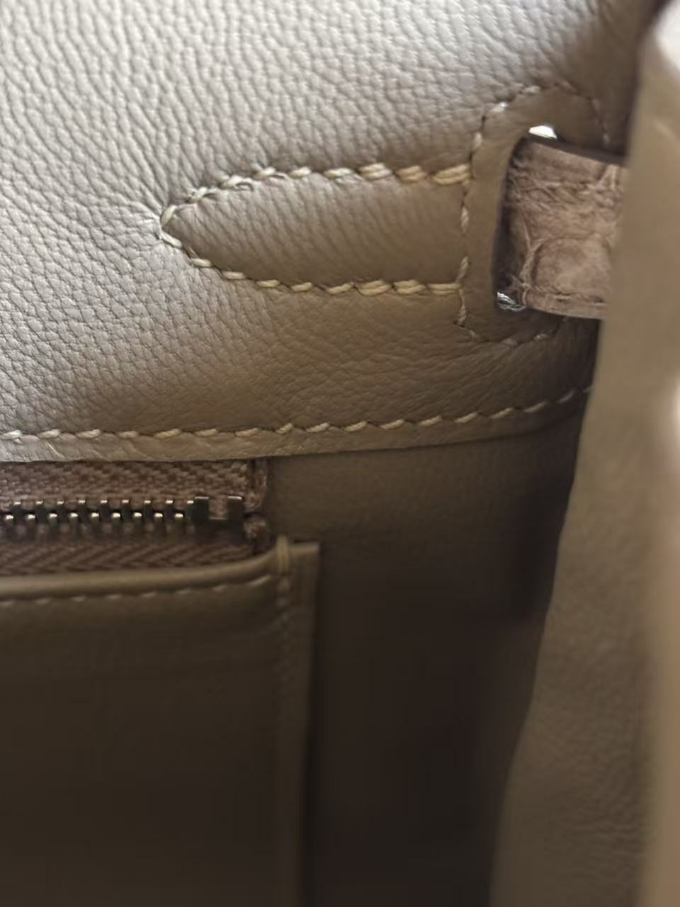 Expert macro view of the hand-saddle stitching at the handle attachment point inside a Himalayan Birkin
