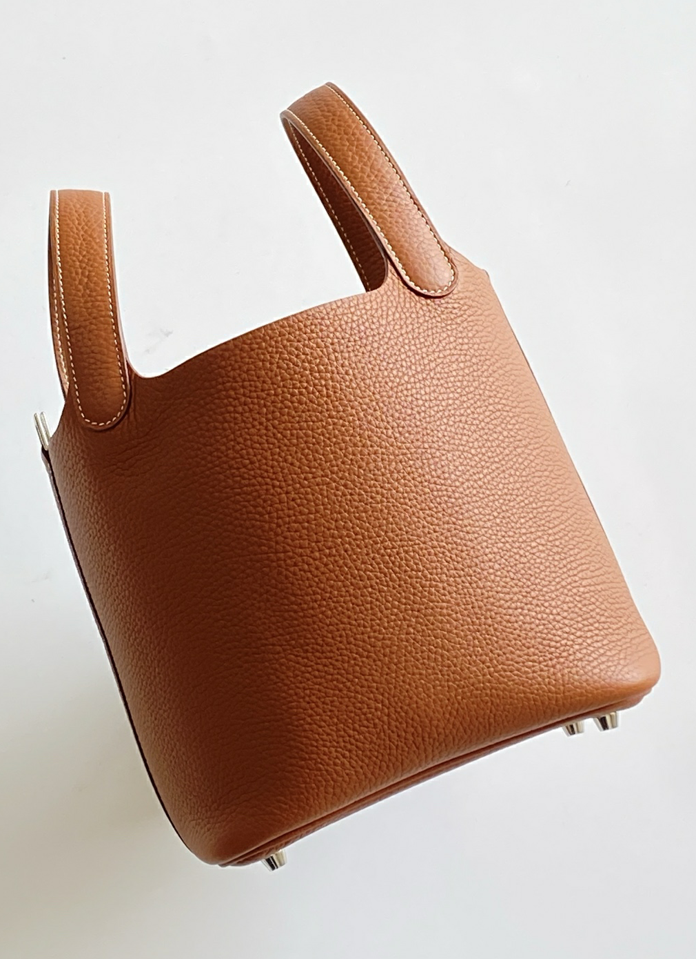 Angled back view of the Picotin 18 bag, showcasing the beautiful drape and high-density fiber structure of premium Taurillon Clemence leather.